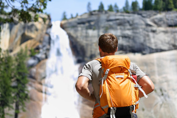 Wall Mural - Hiker hiking looking at waterfall in Yosemite park