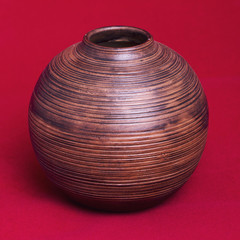 old Hand made Wooden Vase on a red background.