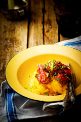 Canvas Print - roast beef and polenta in an iron bowl on a wooden table.