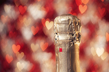 Bottle Of Champagne Over Over Hearts Shaped Abstract Background