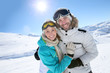 © goodluz - Cheerful couple having fun at top of ski slope