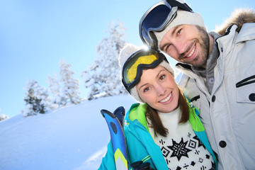 Wall Mural - Portrait of cheerful couple in snowy mountain