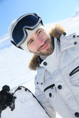 Wall Mural - Portrait of cheerful snowboarder at top of ski slope