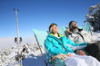 © goodluz - Couple of skiers sunbathing in long chairs