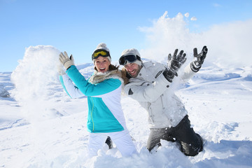 Wall Mural - Couple in snowy mountain doing snowballs fight