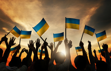 Canvas Print - Group of People Waving Ukranian Flags in Back Lit