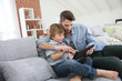 © goodluz - Father with little boy using digital tablet at home