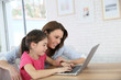 © goodluz - Mother and daughter playing on laptop computer