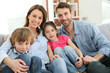 © goodluz - Cheerful family at home sitting in sofa
