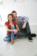 © goodluz - Trendy couple sitting on house floor