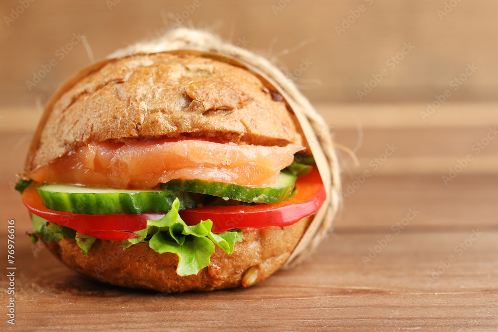 Sandwich with salmon on wooden background