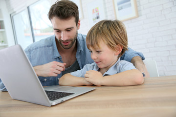 Daddy and son playing on laptop computer