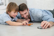 © goodluz - Daddy with little boy playing with toy cars