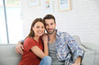 © goodluz - Cheerful young couple relaxing in sofa at home
