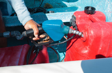 Man fueling tank of a motor boat before travel