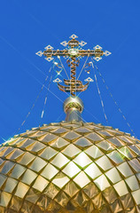 Poster - Golden orthodox cross against blue sky background