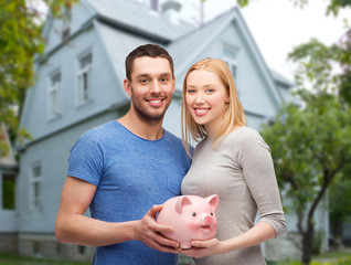 Sticker - smiling couple holding piggy bank over house