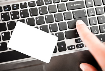 Closeup of a man shopping online using laptop with credit card.