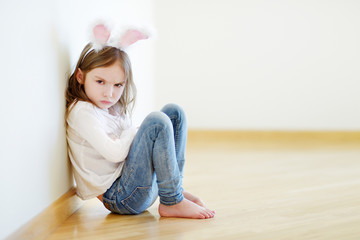 Angry little girl wearing bunny ears