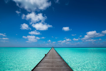 Wooden pier with blue sea and sky background