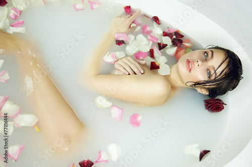 Fototapeta na wymiar Beautiful sexy woman takes bath rose candles Valentine's day spa