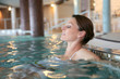 © goodluz - Beautiful woman relaxing in spa swimming-pool