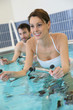 © goodluz - Couple in pool doing aquabike training