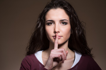 Beautiful girl making silence gesture