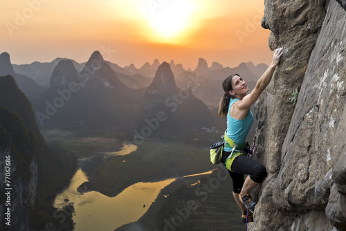 Fotomural Escalador femenino contra la puesta de sol en el río Li