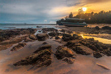 Beautiful Sunrise View With Rocks Structure And A Boat Park On T