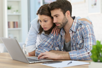 Couple at home websurfing on internet