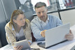© goodluz - Business people in office working on laptop and tablet