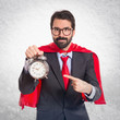 Businessman dressed like superhero holding a clock