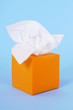 Orange tissue box kleenex style tissues isolated blue background photo
