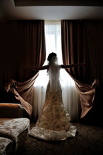 Silhouette Of The Bride Standing At The Window Of Their Wedding