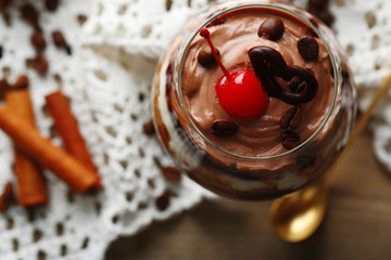 Sticker - Tasty tiramisu dessert in glass, on wooden background