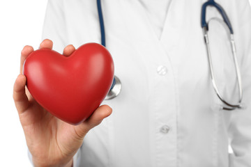 Stethoscope with heart in doctor hands, close-up