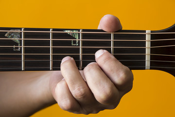 Hand performing D chord on guitar