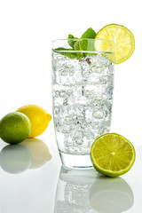 Glass o sparkling water with ice cubes on white background