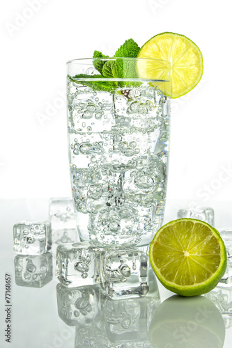 Naklejka dekoracyjna Glass o sparkling water with ice cubes on white background