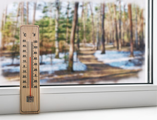 thermometer on a frozen window and cold weather in the spring st