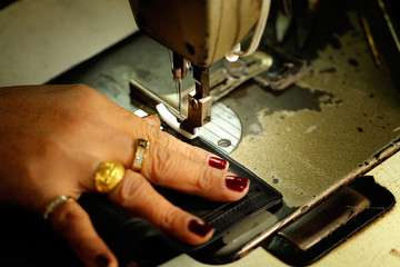 tailor working on a sewing machine at textile factory