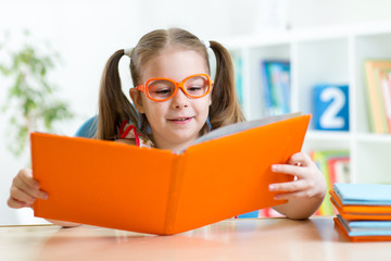 Wall Mural - Little girl reading a book