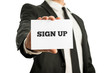 © Gajus - Businessman holding up a business card saying Sign up