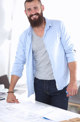 Wall Mural - Portrait of male architect with blueprints at desk in office