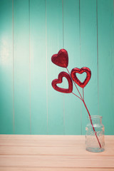 Wall Mural - Red shiny heart ornaments on vintage wood