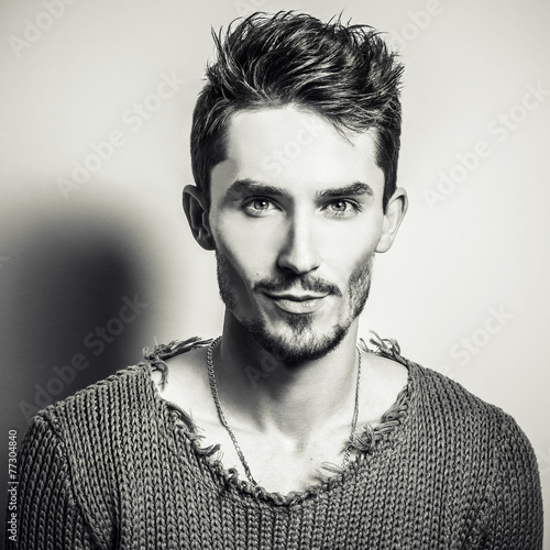 Naklejka na szybę Black-white portrait of young handsome man in knitted sweater.