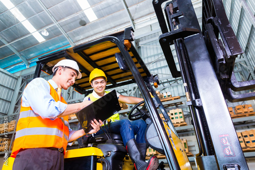 Fotografía Asian forklift truck driver and foreman in storage