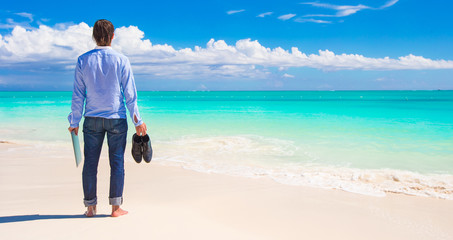 Young man with laptop during tropical beach vacation