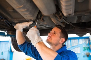 Wall Mural - Mechanic examining under the car